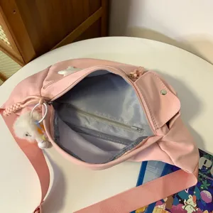 Sac de poitrine en nylon rose vue détaillée avec poche intérieure zippée et pendentif peluche.