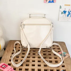 Detailed view of the back side of a cute beige PU leather mini backpack with shoulder straps.