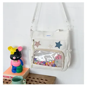 Λευκό καμβά διαφανές τσαντάκι ώμου χιαστί ita bag με πολύχρωμα πομ πομ και αστέρια