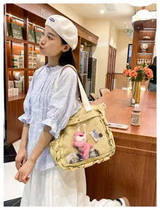 Kawaii Japanese anime ita bag canvas shoulder bag with clear PVC pocket and cute pink bear plush.