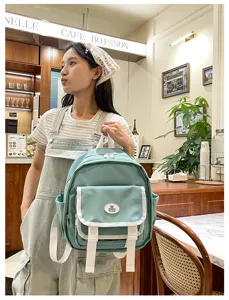 Detail of cute light green mini canvas backpack with white trim, ideal for casual daily wear.