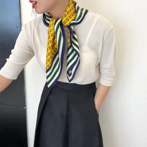 Detalle elegante de bufanda de seda geométrica con diseño cuadrado colorido para mujeres.