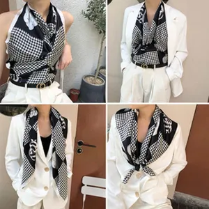 Gedetailleerd overzicht van de zijden sjaal met houndstooth en bloemenprint, elegante stijl.
