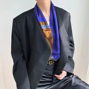 Detailopname van een luxe moerbeizijde sjaal met een elegant blauw en bruin printpatroon.