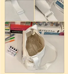Detail view of white canvas ita bag showing adjustable strap and clear pocket structure.
