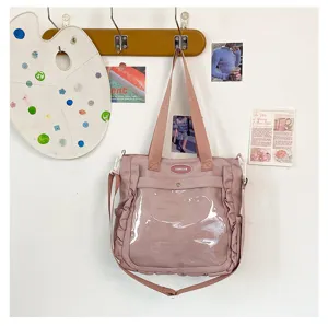 Close-up detail of the pink ita bag featuring a clear window, ruffled trim, and a creative wall display.