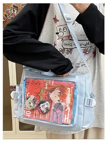 Detailed view of a light blue canvas pain bag with a clear window showcasing anime pins.