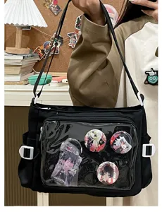 Detail view of black canvas ita bag with clear window showing anime character badges and pins.