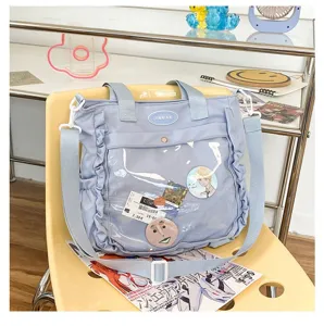 Detail view of light blue ita bag featuring a clear window pocket for pins and custom display.