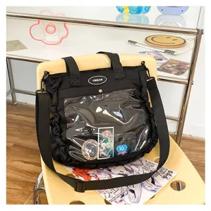 Detail shot of black ita bag with clear window, ruffled side and straps for anime pins display.