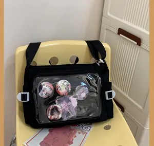 Detailed view of the black canvas ita bag with a clear PVC window showing anime badges inside.