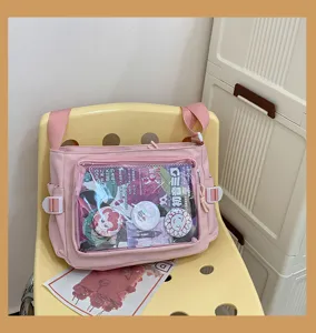 Japanese style pink canvas ita bag with clear window, perfect for pins and anime merch.