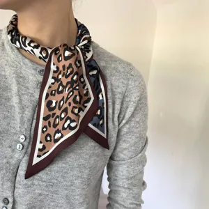 Gros plan détaillé d'un foulard en soie à imprimé léopard chic noué autour du cou, élégant.
