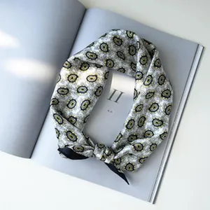 Detailopname van de elegante zijden sjaal met een prachtig klassiek paisleymotief.