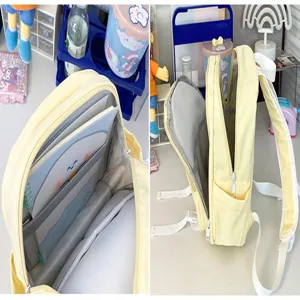 Details of the light yellow backpack showing multiple inner compartments and side pockets clearly.
