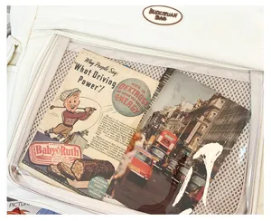 Vue détaillée d'un sac ita en toile crème avec fenêtre transparente et affiches vintage.
