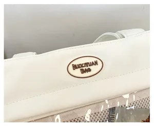 Détail de sac ita en toile affichant une fenêtre en filet et un patch en caoutchouc.