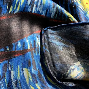 Close-up detail of luxury silk scarf featuring famous starry night artistic pattern texture.