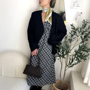 Detailaufnahme des Seidentuchs gestylt mit schwarzem Blazer und Karokleid in schicker Szene.