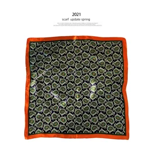 Klassieke paisley print zijden vierkante sjaal met een levendige oranje rand.