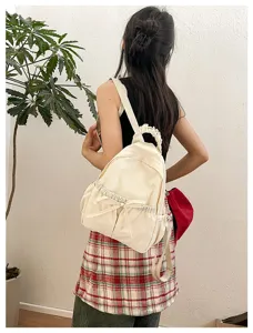 Gedetailleerd achteroverzicht van een schattige nylon rugzak met stijlvolle strik en handvat.