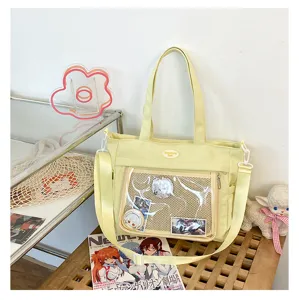Vue détaillée du sac cabas jaune en toile avec fenêtre transparente et de jolies épingles anime.