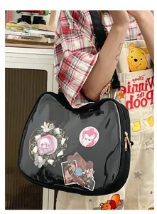 Detailed view of the black transparent cat ita bag showcasing anime badges and cute pins.