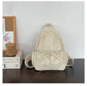 Gedetailleerd overzicht van de beige nylon rugzak met schattige strik en casual stijl.