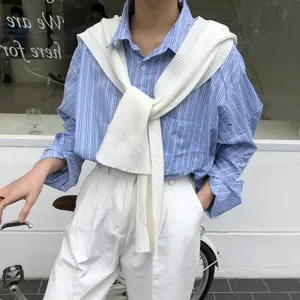 Women's stylish knit shoulder shawl paired with striped shirt and white pants outfit
