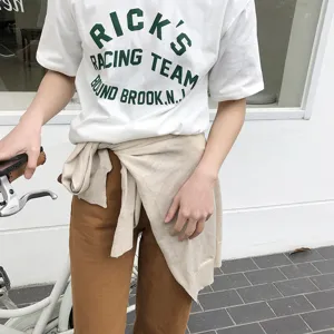 Vue détaillée du t-shirt blanc décontracté et pull en tricot noué à la taille, style quotidien.
