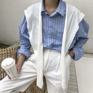 Femme chemise rayée bleu blanc avec châle en tricot blanc et pantalon mode casual