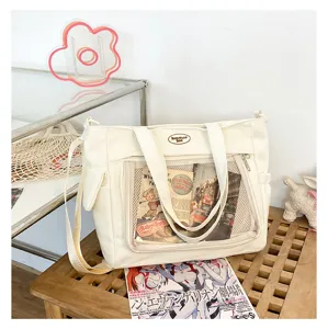 Detail du sac ita en toile avec fenetre transparente avant et texture en tissu blanc.