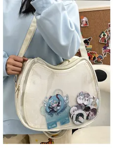 Detail view of a white cat-shaped ita bag featuring clear display window and anime merchandise inside.