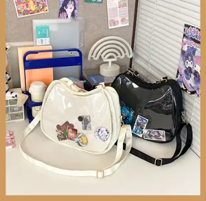 Clear ita bag detail showing transparent front pocket and cute anime sticker decorations on desk.