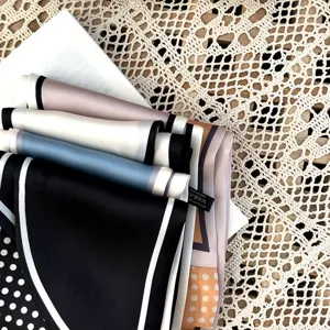 Gros plan détaillé de foulards en soie élégants avec motif pois et bordure contrastée.