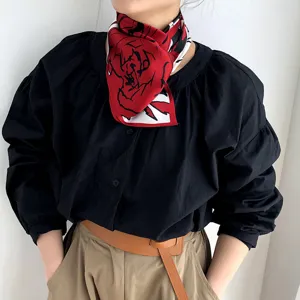 Detalle de pañuelo de seda con rosas rojas, elegante estilo de cuello vintage francés.