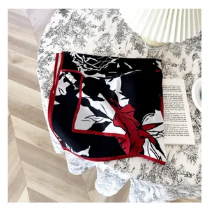 Elegante pañuelo cuadrado de seda con diseño floral rojo y borde contrastante.