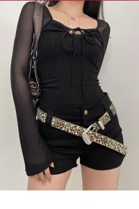 Dettaglio della cintura leopardata con strass, fibbia di cristallo scintillante, accessorio.