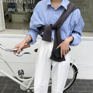 Detailed view of women's stylish knitted sweater shawl over shoulder, casual summer top.