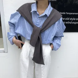 Stylish women knit shoulder drape sweater paired with casual striped shirt for versatile daily wear.