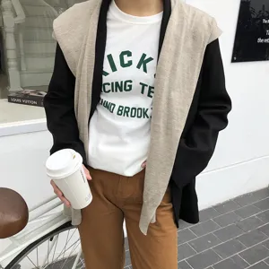 Vue détaillée d'un châle en tricot de style coréen superposé avec blazer, mode de rue.