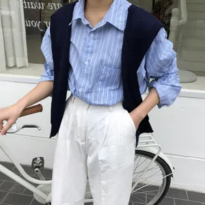 Detailed view of women knitted vest shoulder wrap with striped long sleeve shirt casual style