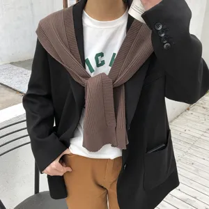 Knit over shoulder sweater shawl detail shot, stylish black blazer and white tee outfit.