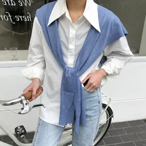 Vue détaillée d'un pull en tricot élégant pour femme sur chemise blanche classique.
