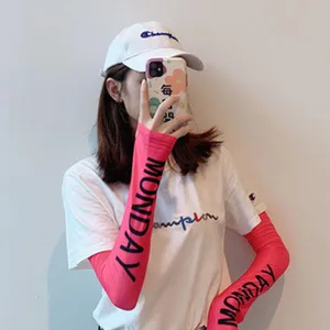 Detail shot of pink sun protection arm sleeves with stylish printed lettering for outdoor wear.