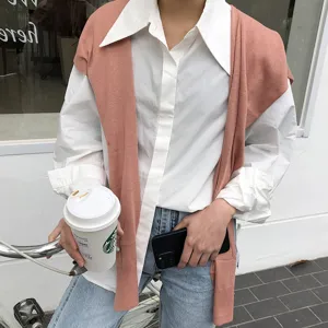 Châle en tricot décontracté sur chemise blanche classique et jeans pour un look chic.
