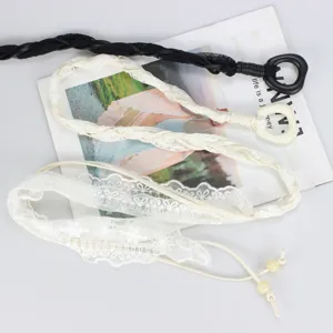 Detailed shot of braided lace waist belt, delicate tassel and pearl beads, clothing accessory.