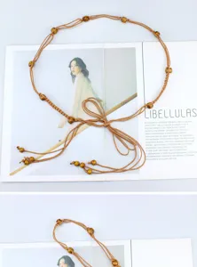 Etnische gevlochten dunne tailleceintuur met houten kralen, stijlvol boho jurk accessoire.