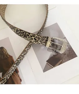 Primo piano di un'elegante cintura leopardata in strass con cristalli scintillanti e fibbia.