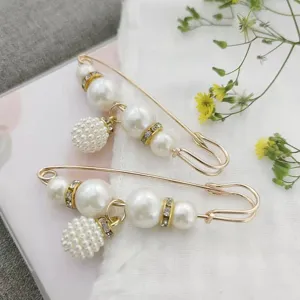 Gold pearl rhinestone safety pin brooch detail, decorative waist tightener and clothing accessory.